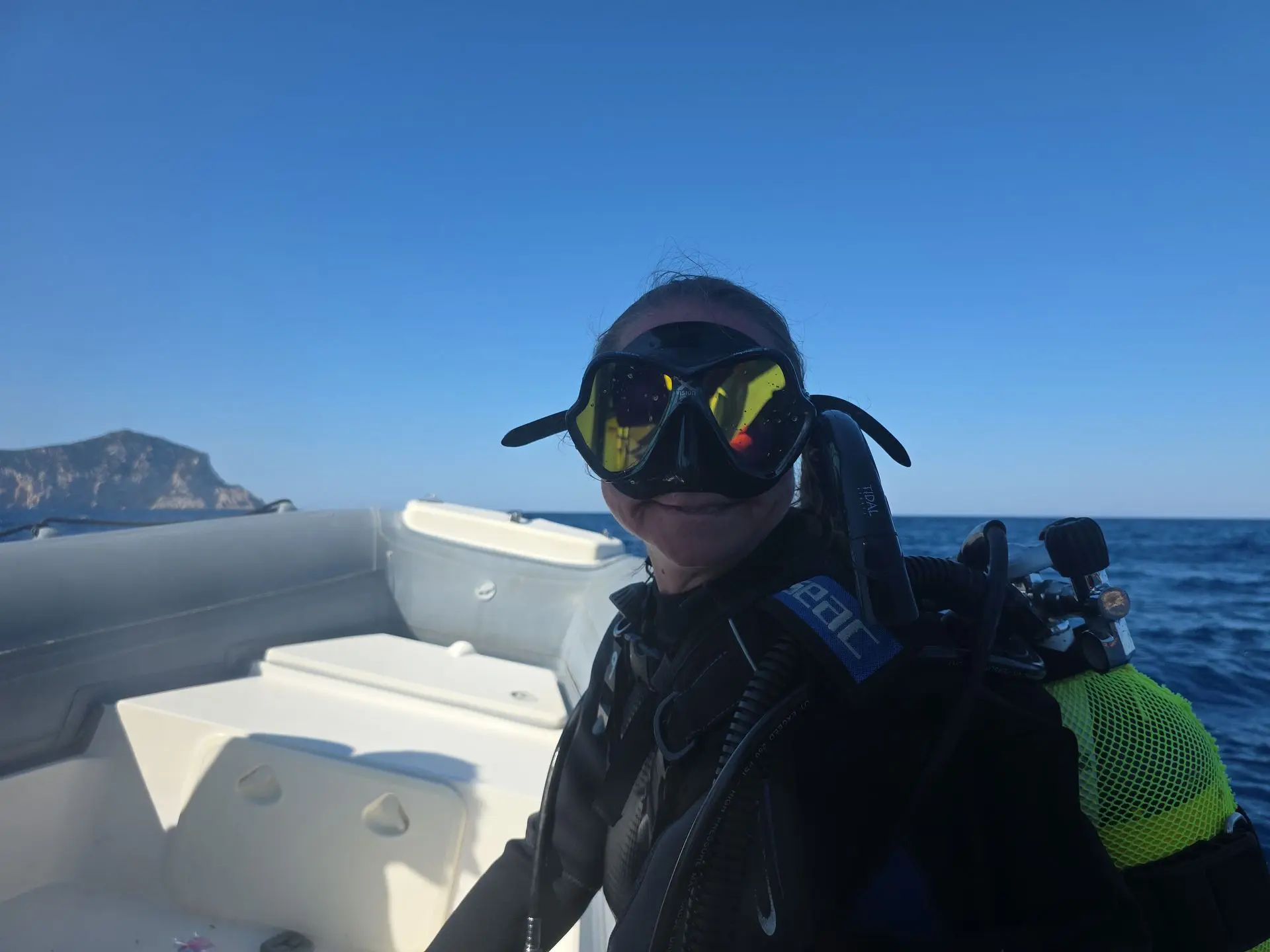 Scuba diver on a boat with Tavolara island in the background