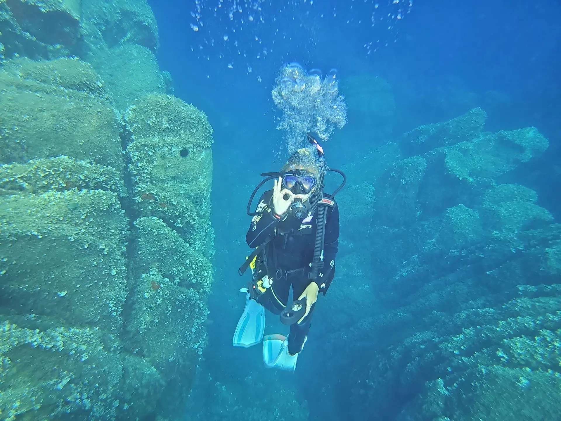 Scuba diver exploring a granite reef in clear Sardinian water
