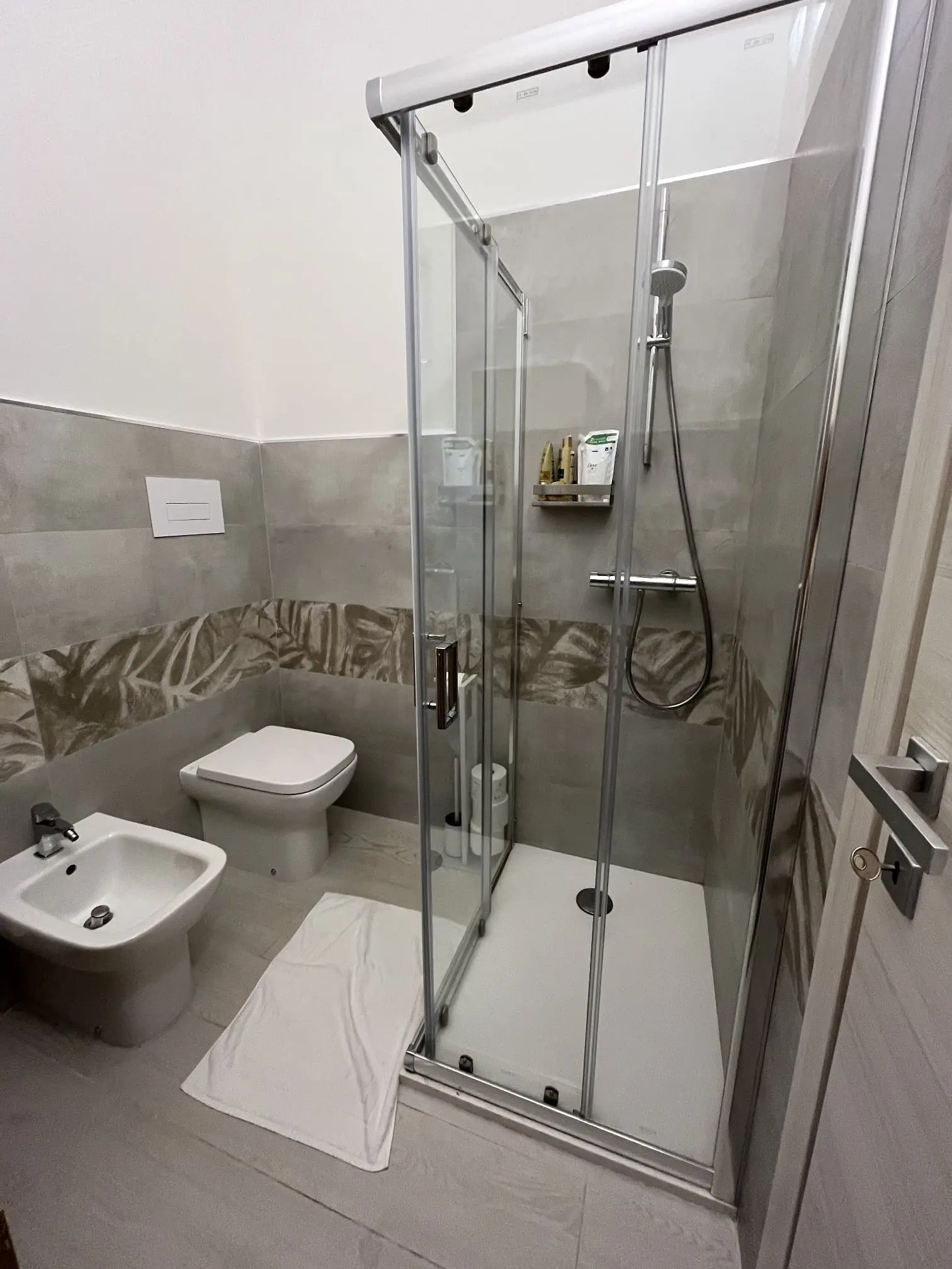 Renovated indoor bathroom with glass shower, toilet and bidet at San Teodoro Beach Villa 86B