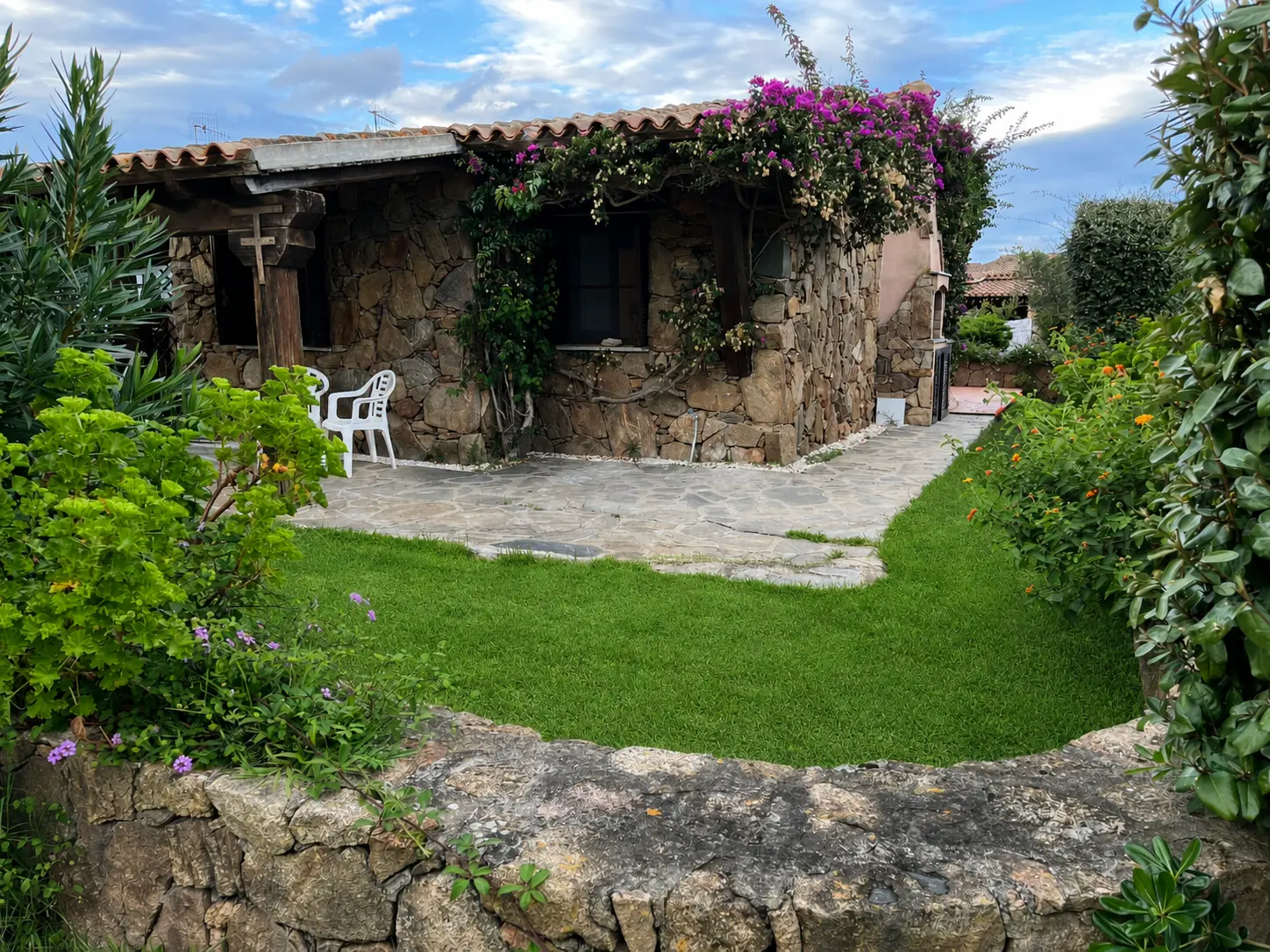 Bougainvillea-covered stone villa beside the private garden and terrace