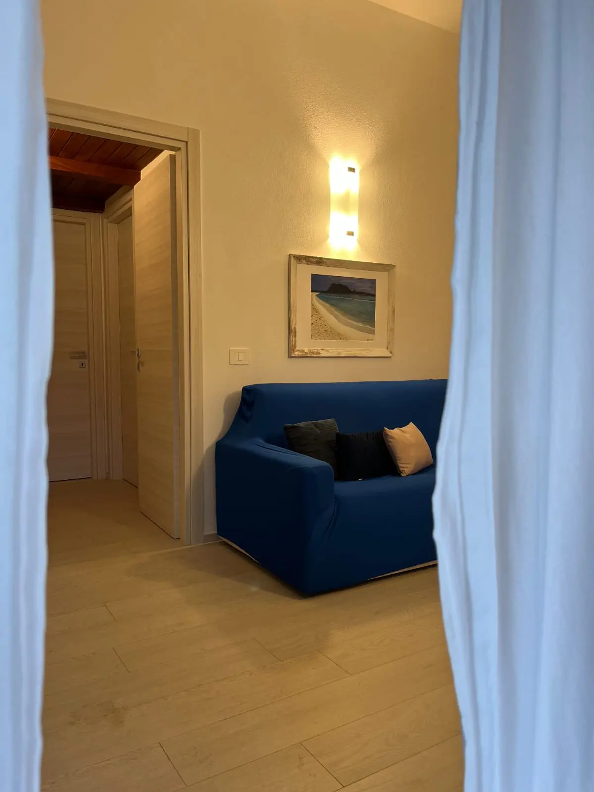 Blue sofa in the living area beside the bedroom hallway