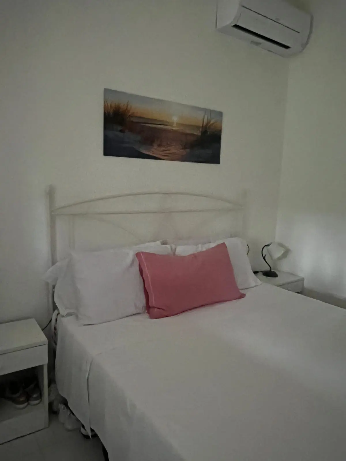 Air-conditioned main bedroom with queen-size bed and sunset artwork