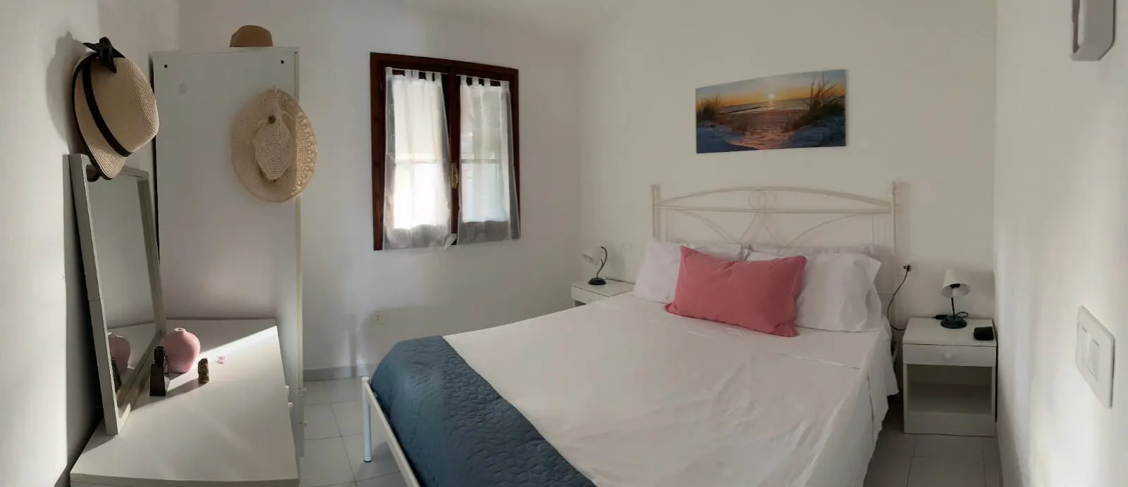 Panoramic view of the bright main bedroom with queen-size bed