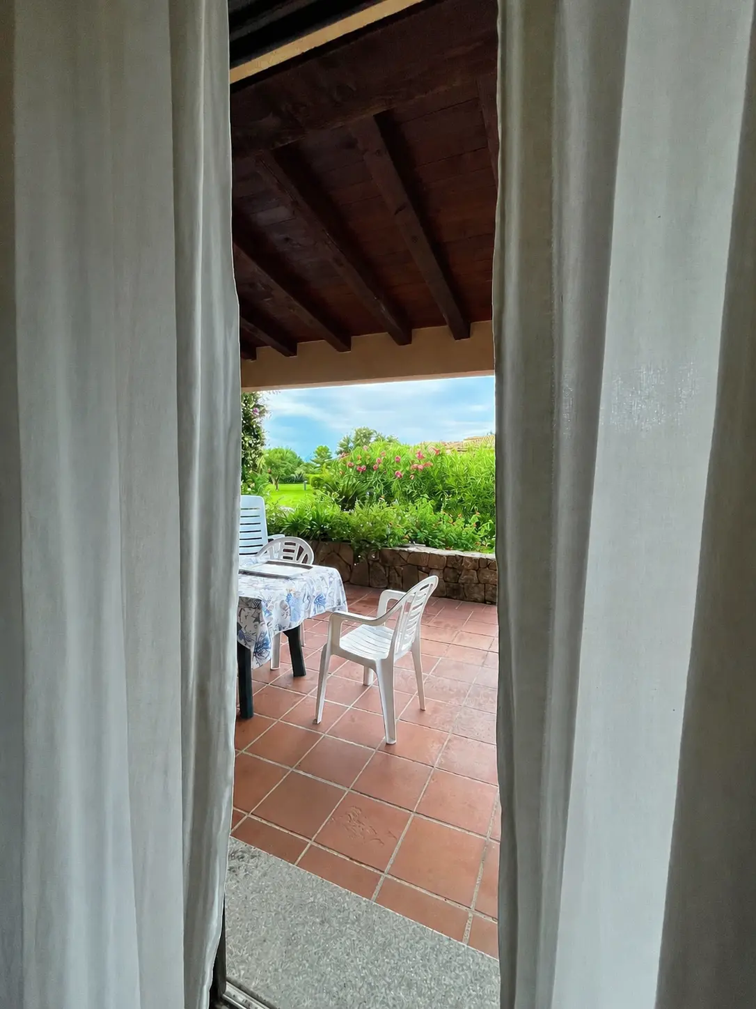 Covered outdoor dining terrace viewed through the villa doorway