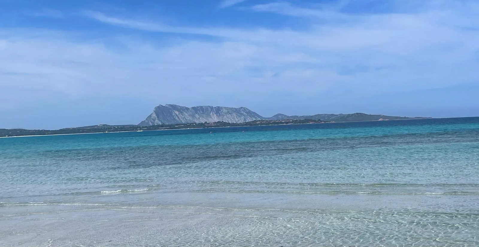 Shallow turquoise water on the San Teodoro coast with Tavolara on the horizon
